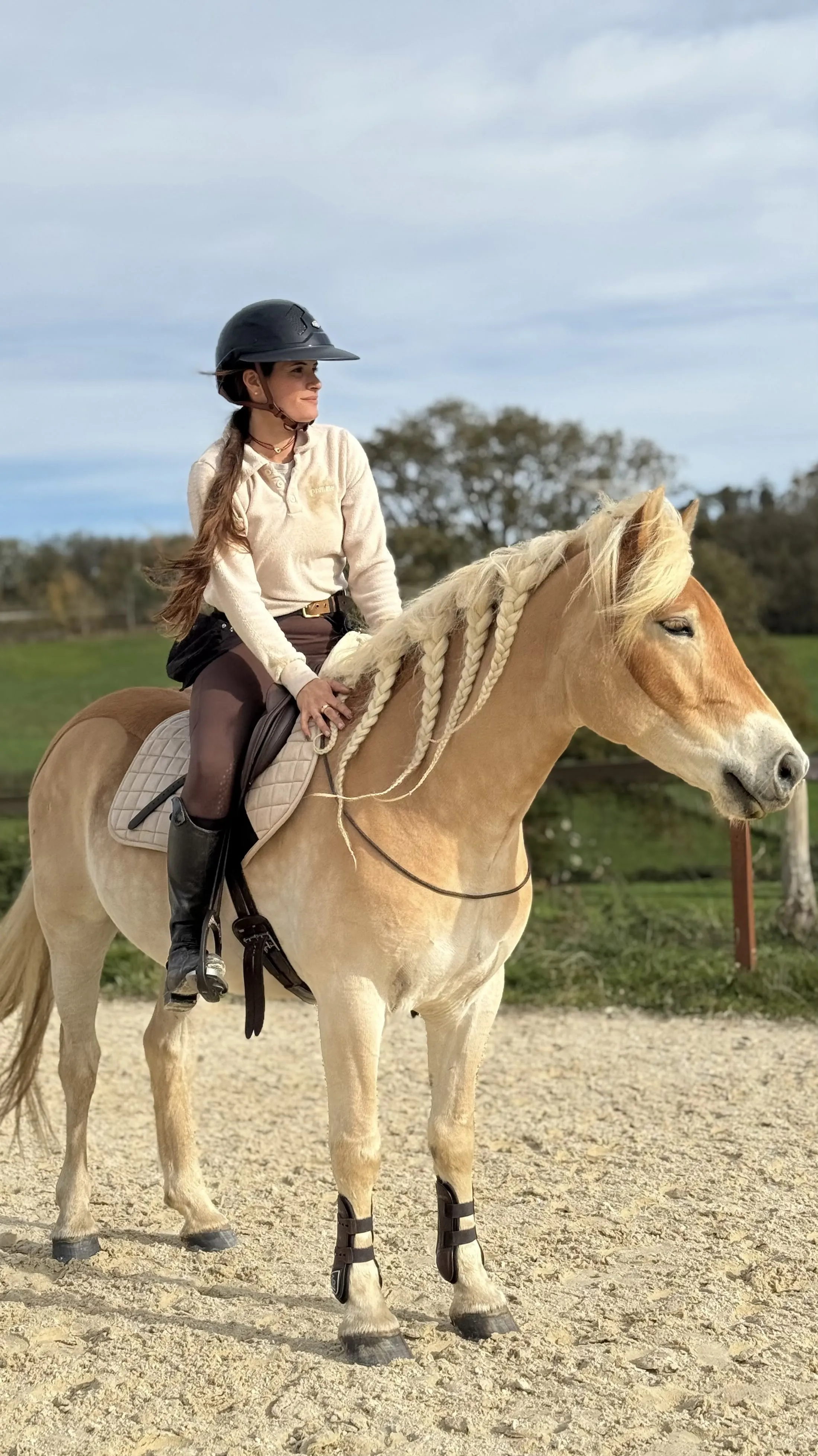 Marie en selle sur Mustang, crinière tressée, dans la carrière en automne